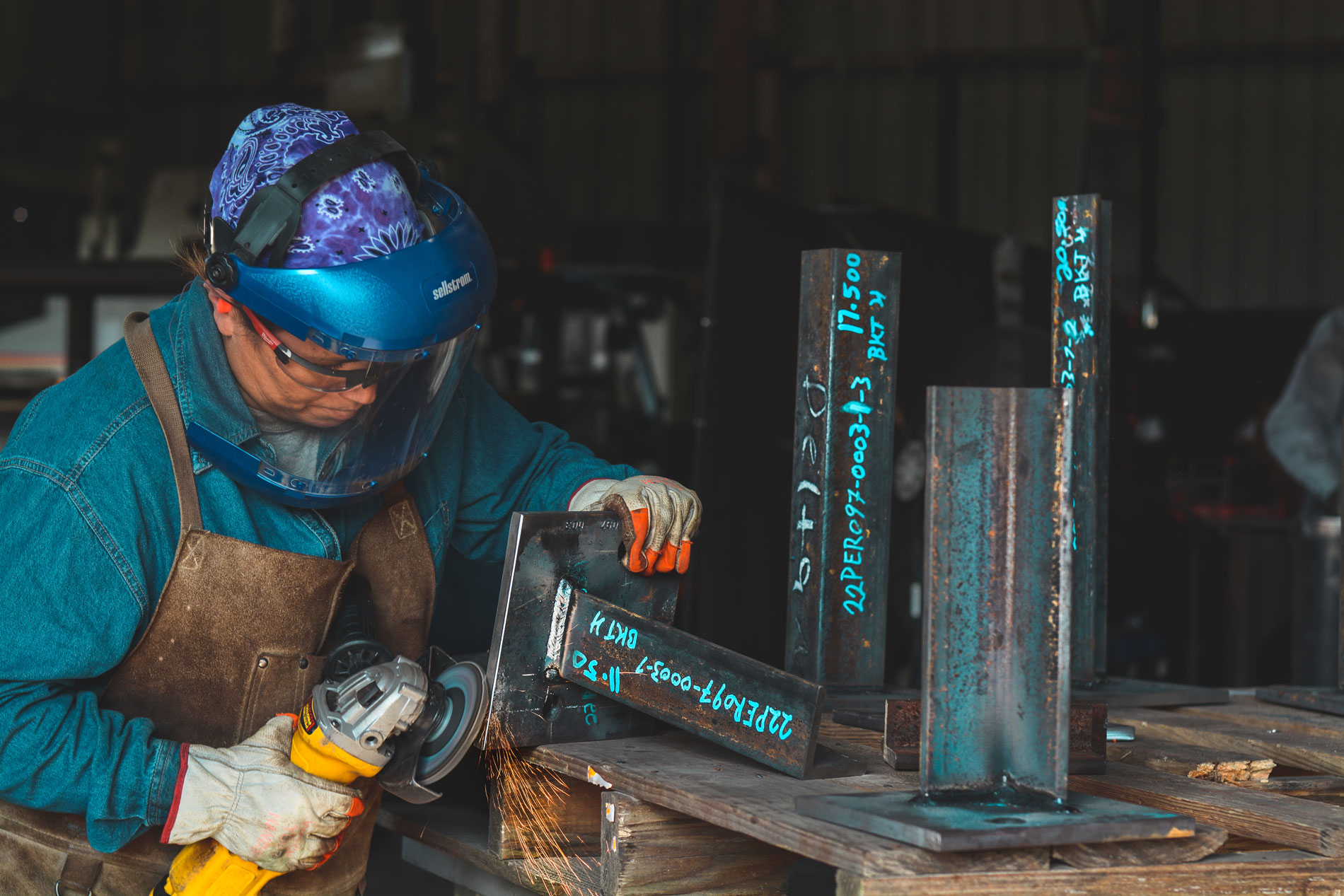 Fabricator measuring and marking steel before cutting