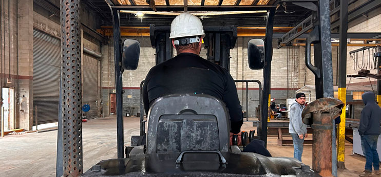 Forklift operator moving material inside a distribution warehouse