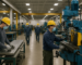 Manufacturing workers in PPE operating machinery in a Sioux Falls facility, hiring in Sioux Falls