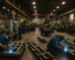 Skilled trades workers on a manufacturing floor in southwest Michigan, including welders and machine operators.