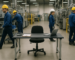 Empty workstation on a busy manufacturing plant floor, showing the cost of leaving a production position unfilled