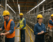 Workers in safety gear operating machinery at a Fort Wayne manufacturing plant