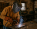 Skilled trades worker welding in a Dunlap and Whitwell industrial workshop